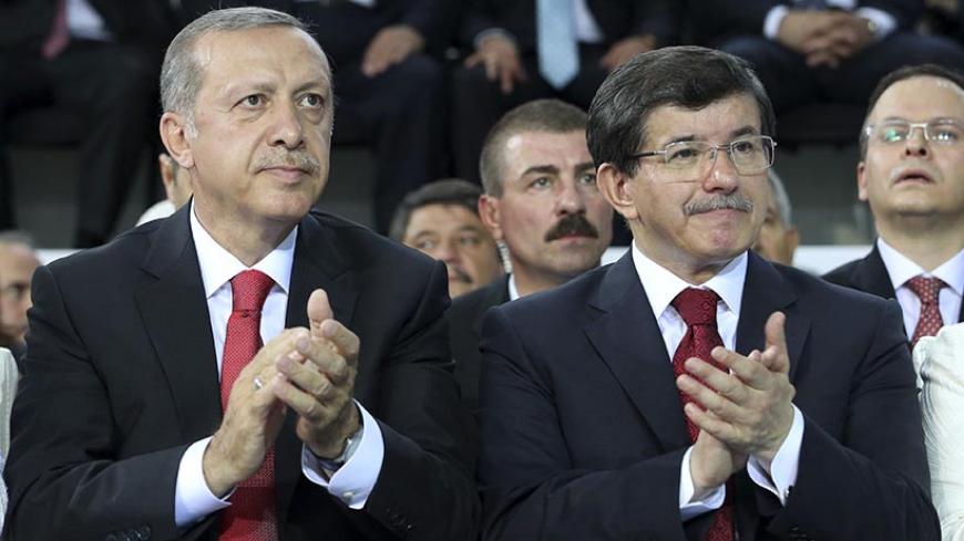 Turkey's Prime Minister Tayyip Erdogan (L) and Foreign Minister Ahmet Davutoglu applaud during the Extraordinary Congress of the ruling AK Party (AKP) to choose a new leader of the party, ahead of Erdogan's inauguration as president, in Ankara August 27, 2014. Turkish president-elect Erdogan said on Wednesday he would ask incoming prime minister Ahmet Davutoglu to form a new government on Thursday, and a new cabinet of ministers would be announced the following day.   REUTERS/Rasit Aydogan/Pool  (TURKEY - T