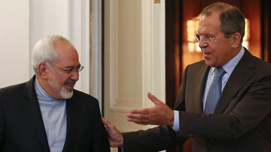 Russian Foreign Minister Sergei Lavrov (R) shows the way to his Iranian counterpart Javad Zarif during a meeting in Moscow, August 29, 2014. Russia said on Thursday the possibility of lifting sanctions on Iran had emerged thanks to international talks on Tehran's nuclear program and urged all countries involved to show political will to reach a deal. Iranian Foreign Minister Mohammad Javad Zarif will meet his Russian counterpart Sergei Lavrov in Moscow on Friday to discuss the negotiations with six world po