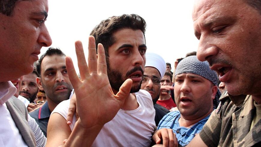 Lebanese army soldier Ibrahim Moustafa Shaaban, who was captured by Islamist militants in Arsal, gestures upon his arrival in Al-Mohamara village after his release, in Akkar August 31, 2014. Islamist Nusra Front, a group linked to al Qaeda, on Saturday released four Sunni soldiers and a Sunni policeman whom they captured earlier this month, including Shaaban, a source close to the group said. The circumstances of their release were not immediately clear. REUTERS/Stringer (LEBANON - Tags: CIVIL UNREST TPX IM