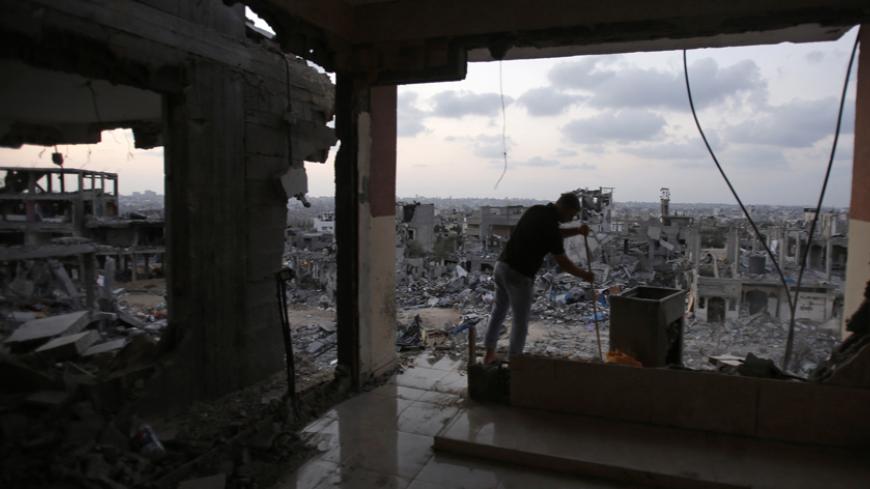 A Palestinian man cleans his house, which witnesses said was badly damaged during the seven-week Israeli offensive, in the east of Gaza City August 31, 2014. Fifty days of war in one of the most densely populated parts of the world have left swathes of Gaza in ruins. With the economy reeling under an Israeli-Egyptian blockade, the enclave now faces an almost impossible task of rebuilding. Picture taken August 31, 2014. REUTERS/Suhaib Salem (GAZA - Tags: CIVIL UNREST BUSINESS CONSTRUCTION POLITICS CONFLICT) 
