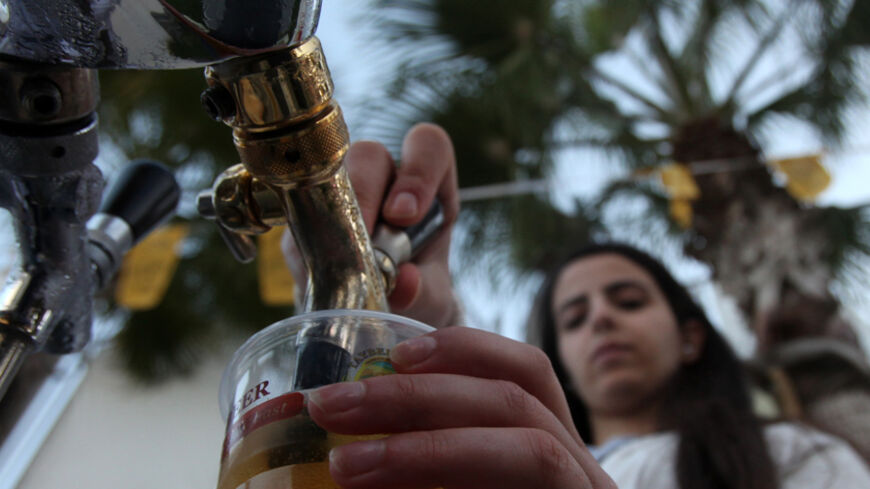 A woman serves beer during the 2013 Taybeh Oktoberfest beer festival in the West Bank Christian village of Taybeh, near Ramallah, on October 5, 2013. The annual beer festival is put on by the Taybeh brewery, the only such establishment in the predominantly Muslim Palestinian territories.  AFP PHOTO/ABBAS MOMANI        (Photo credit should read ABBAS MOMANI/AFP/Getty Images)