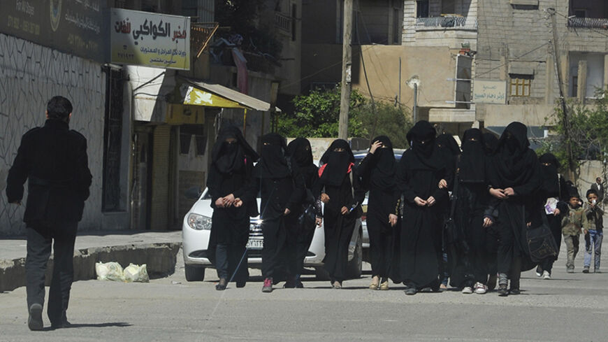 Female school students wearing a full veil (niqab) walk along a street in the northern province of Raqqa March 31, 2014. The Islamic State in Iraq and the Levant (ISIL) has imposed sweeping restrictions on personal freedoms in the northern province of Raqqa. Among the restrictions, Women must wear the niqab, or full face veil, in public or face unspecified punishments "in accordance with sharia", or Islamic law. REUTERS/Stringer   (SYRIA - Tags: POLITICS CIVIL UNREST CONFLICT RELIGION SOCIETY EDUCATION TPX 