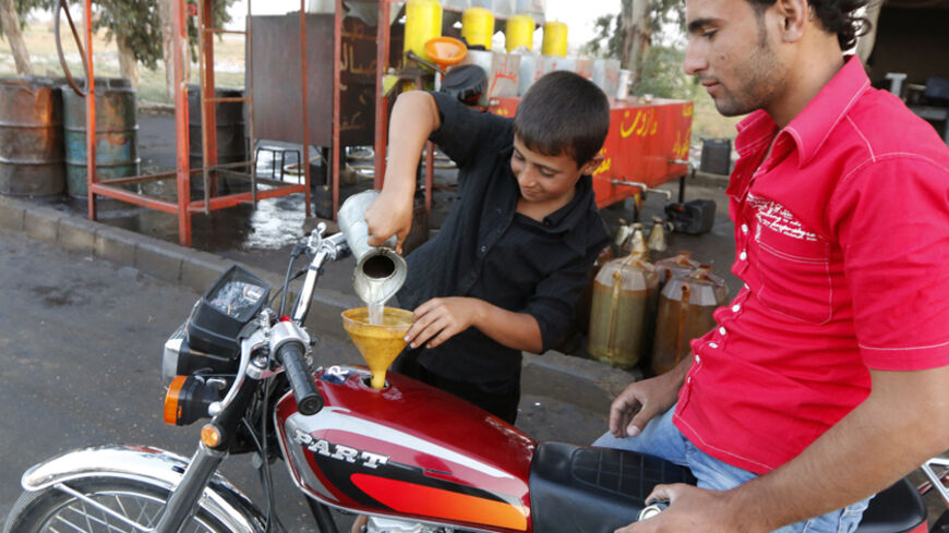 A boy fills up a motorbike with diesel along a street in the Islamic State's stronghold of Raqqa September 30, 2014. Activists said that the price of the diesel and gasoline has increased since the beginning of the air raids believed to have been carried out by U.S.-led forces against Islamic State (IS) militants. Air strikes believed to have been carried out by U.S.-led forces hit three makeshift oil refineries in Syria's Raqqa province early on Sunday as part of an assault to weaken Islamic State (IS) mil