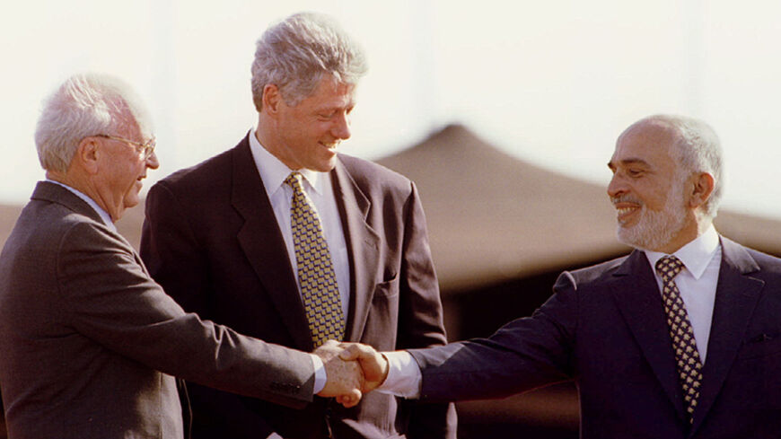 US President Bill Clinton applauds as Jordan s King Hussein reaches out and shakes hands with Israeli Prime Minister Yitzhak Rabin (L) at the end of the Israeli - Jordanian peace treaty signing ceremony - RTXF6XE