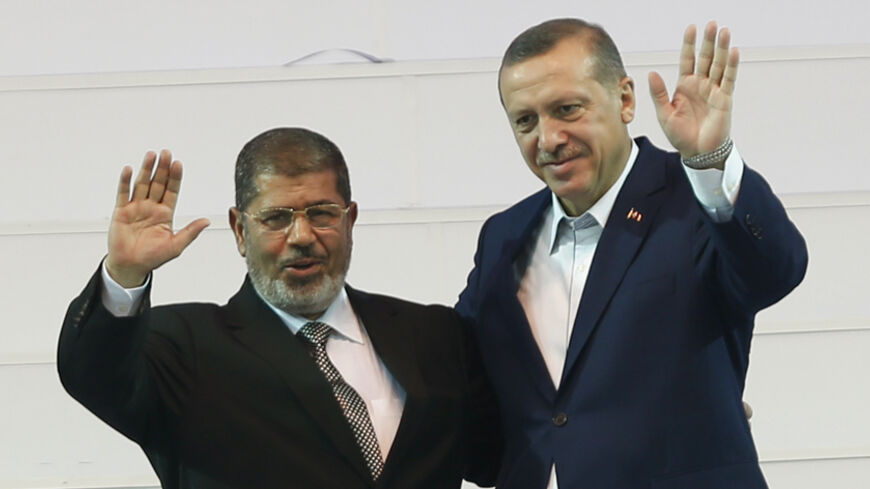 Turkey's Prime Minister and leader of ruling Justice and Development Party (AKP) Tayyip Erdogan (R) and his guest, Egypt's President Mohamed Mursi greet the audience during the AKP congress in Ankara September 30, 2012. REUTERS/Murad Sezer (TURKEY - Tags: POLITICS) - RTR38LZD