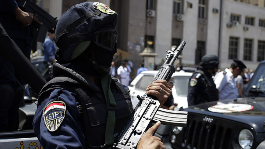 Members of special police forces stand guard as police investigate the car from which an explosive device attached to it detonated outside a court in the Heliopolis area in Cairo, June 25, 2014. One person was wounded from the small explosion outside the court on Wednesday, the head of Cairo's bomb disposal unit told Reuters. At least four people were wounded in a series of small explosions in metro stations in Greater Cairo earlier in the day. REUTERS/Asmaa Waguih (EGYPT - Tags: POLITICS CIVIL UNREST) - RT