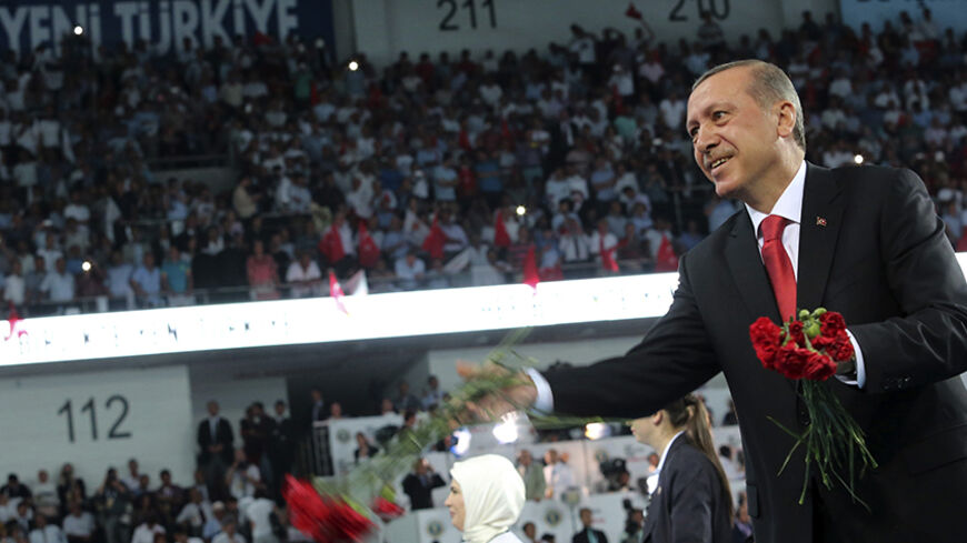 Turkey's Prime Minister Tayyip Erdogan throws flowers to his supporters upon arriving at the Extraordinary Congress of the ruling AK Party (AKP) to choose a new leader of the party, ahead of Erdogan's inauguration as president, in Ankara August 27, 2014. Turkish president-elect Erdogan said on Wednesday he would ask incoming prime minister Ahmet Davutoglu to form a new government on Thursday, and a new cabinet of ministers would be announced the following day.   REUTERS/Rasit Aydogan/Pool  (TURKEY - Tags: P