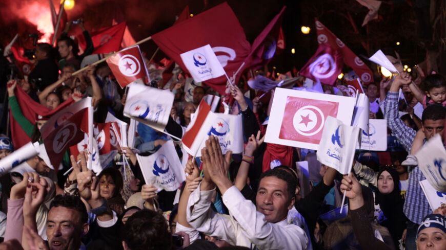 Supporters of the Islamist Ennahda movement wave party flags during a campaign event in Tunis October 24, 2014. Tunisia will hold parliamentary elections on October 26 and a presidential ballot in November. REUTERS/Zoubeir Souissi (TUNISIA - Tags: ELECTIONS POLITICS) - RTR4BIKG