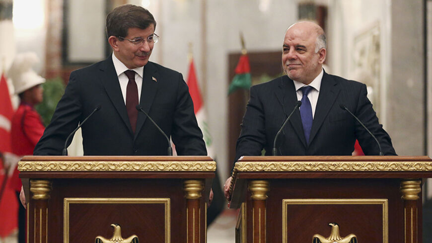 Iraqi prime Minister Haider al-Abadi (R) speaks at a news conference with Turkey's Prime Minister Ahmet Davutoglu in Baghdad, November 20, 2014. REUTERS/Hadi Mizban/Pool (IRAQ - Tags: POLITICS) - RTR4EWED