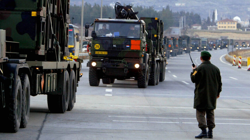 A Turkish non-commissioned officer secures the road for a convoy of
Dutch army trucks carrying Patriot missile units and system parts as
they leave the southern Turkish coastal city of Iskenderun March 1,
2003. The second part of a Dutch patriot missiles system arrived in
Turkey to be deployed in southeast Turkish bases for protection against
a possible Iraqi strike. The Turkish parliament is due to hold a
crucial debate on Saturday to discuss the deployment of 62,000 U.S.
troops on its soil for a possible 