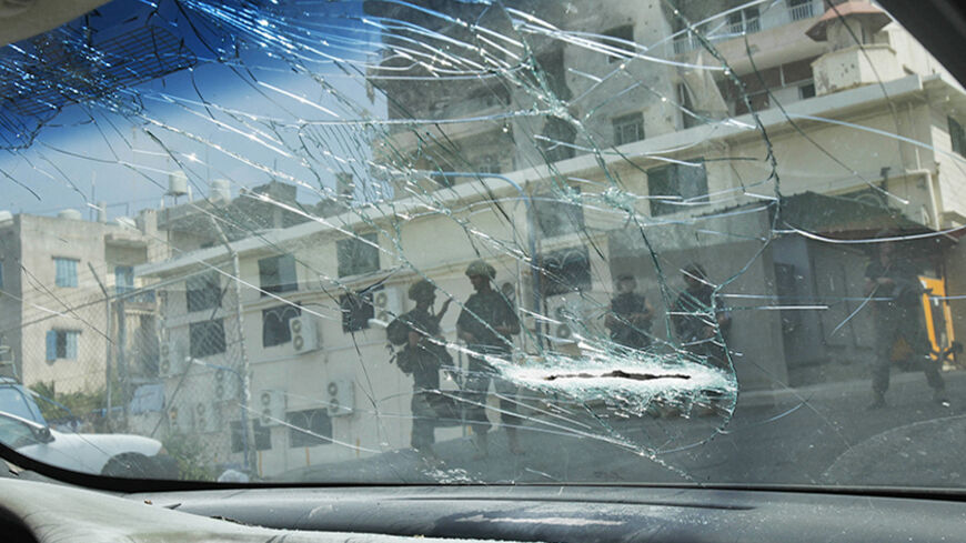 Lebanese army soldiers are seen through a shattered car window as they secure the area near a mosque complex, where hardline Sunni cleric Sheikh Ahmed al-Assir was believed to be sheltering with his supporters, in Abra near Sidon, southern Lebanon, June 25, 2013. The Lebanese government will try on Tuesday to secure the country after the deadliest violence since the start of a two-year conflict in neighbouring Syria that has pushed Lebanon's myriad militia to clashes.Gunfights between the army and Sunni Mus