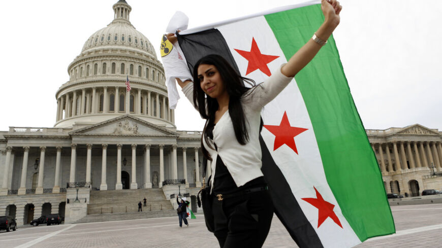 An anti-Assad protester carries the Syrian freedom flag in front of the U.S. Capitol in Washington September 9,  2013.  White House efforts to convince the U.S. Congress to back military action against Syria are not only failing, they seem to be stiffening the opposition. That was the assessment on Sunday, not of an opponent but of an early and ardent Republican supporter of Obama's plan for attacking Syria, the influential Republican chairman of the House intelligence committee, Mike Rogers. Congress will 