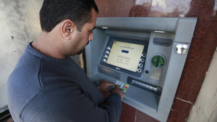 A man uses an ATM machine at a bank in Baghdad March 4, 2012. The lack of efficient banking is holding the country back as it rebuilds its economy after the underinvestment of the Saddam Hussein years and the turmoil that followed the 2003 U.S.-led invasion. Without banks that are integrated into the global financial system, foreign investors outside the oil sector are likely to continue hesitating to commit large sums to Iraq. Picture taken March 4, 2012. To match Feature IRAQ-BANKING/      REUTERS/Mohamme