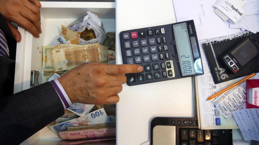 A money changer calculates the exchange rate of Turkish lira to Syrian pound at his office in the southern Turkish town of Reyhanli November 29,2012.  REUTERS/Laszlo Balogh (TURKEY - Tags: BUSINESS POLITICS) - RTR3B0WS