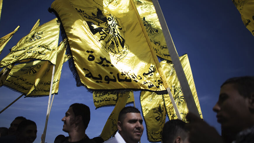 Palestinian Fatah supporters carry Fatah flags during a rally marking the tenth anniversary of the death of late Palestinian leader Yasser Arafat, in the West Bank city of Ramallah November 11, 2014. Palestinian President Mahmoud Abbas on Tuesday accused his Islamist Hamas rivals of carrying out a series of bombings against officials loyal to him in Gaza last week, in a move sure to harm already floundering unity efforts. REUTERS/Finbarr O'Reilly (WEST BANK - Tags: POLITICS ANNIVERSARY RELIGION OBITUARY) - 