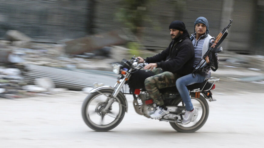 Rebel fighters ride a motorbike in the old city of Aleppo December 7, 2014. Picture taken December 7, 2014. REUTERS/Abdalrhman Ismail (SYRIA - Tags: POLITICS CIVIL UNREST CONFLICT) - RTR4H3I6