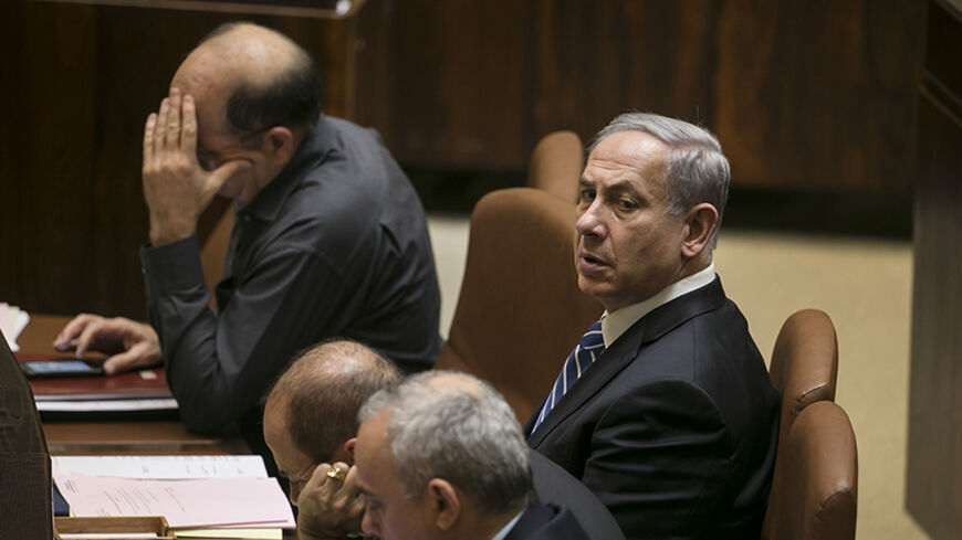 Israel's Prime Minister Benjamin Netanyahu sits before a vote to dissolve the Israeli parliament, also known as the Knesset, in Jerusalem 
December 8, 2014. Israel's parliament voted on Monday to dissolve itself in preparation for an early general election on March 17, after a crisis set in motion by Netanyahu's dismissal of two ministers. 
REUTERS/Baz Ratner (JERUSALEM - Tags: POLITICS) - RTR4H6JJ