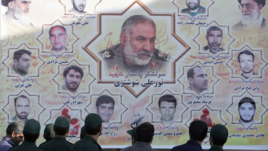 Members of Iran's Revolutionary Guard look at memorial pictures of their commanders and colleagues, who were killed in a suicide attack in southeastern Iran, during a funeral in Tehran outside the Revolutionary Guard garrison on October 20, 2009. Sunni group Jundallah claimed responsibility for the suicide attack that killed seven Revolutionary Guards commanders and 28 other people, including several tribal leaders. AFP PHOTO AFP PHOTO/BEHROUZ MEHRI (Photo credit should read BEHROUZ MEHRI/AFP/Getty Images)
