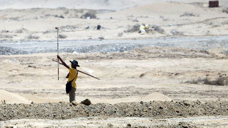 An Egyptian engineer works at the site of an upgrading project on the Suez Canal, in Ismailia port city, northeast of Cairo August 12, 2014. Egypt said last Tuesday it plans to build a new Suez Canal alongside the existing 145-year-old historic waterway in a multi-billion dollar project to expand trade along the fastest shipping route between Europe and Asia. Picture taken August 12, 2014.     REUTERS/Amr Abdallah Dalsh  (EGYPT - Tags: POLITICS BUSINESS SOCIETY) - RTR429HA