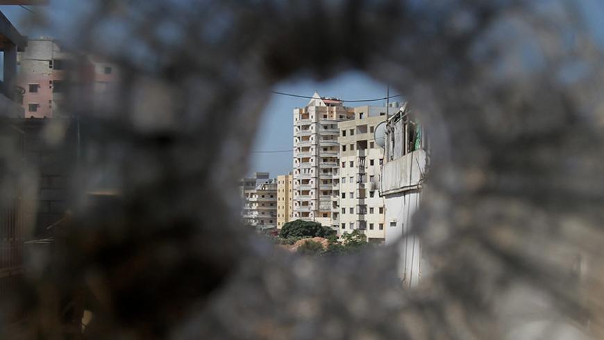 The Alawite neighbourhood of Jabal Mohsen is seen through a bullet hole in the window of an apartment in the Sunni Mankoubin district in Lebanon's northern port of Tripoli on August 25, 2012, following clashes between pro- and anti-Syrian factions in the city, stoking fears of a spillover of bloodshed. AFP PHOTO / ANWAR AMRO        (Photo credit should read ANWAR AMRO/AFP/Getty Images)