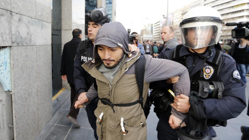 An anti-government protester is detained by riot policemen during a demonstration in Ankara March 12, 2014. Turkish police fired tear gas and water cannon to disperse a crowd of several thousand demonstrators in Ankara's central Kizilay square on Wednesday in a protest triggered by the death of a teenager wounded in street clashes last summer. REUTERS/Umit Bektas (TURKEY  - Tags: POLITICS CIVIL UNREST)   - RTR3GRAH
