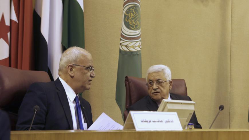 Palestinian President Mahmoud Abbas (R) talks with Palestinian chief negotiator Saeb Erekat as they attend an Arab Foreign Ministers' meeting at the Arab League headquarters in Cairo April 9, 2014. REUTERS/Asmaa Waguih (EGYPT - Tags: POLITICS) - RTR3KJSQ