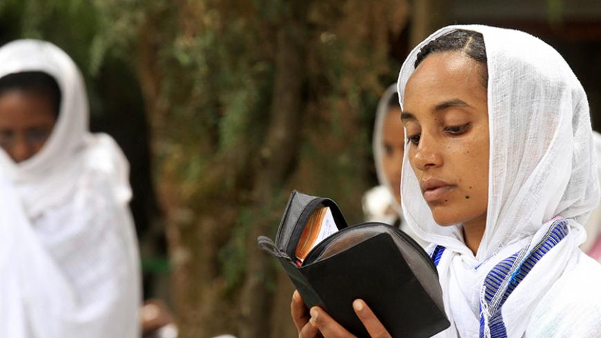 An Ethiopian Orthodox woman reads her bible during the Good Friday prayer ceremony at Medhanialem Orthodox Church in Ethiopia's capital Addis Ababa April 18, 2014. REUTERS/Tiksa Negeri (ETHIOPIA - Tags: SOCIETY RELIGION) - RTR3LTAZ