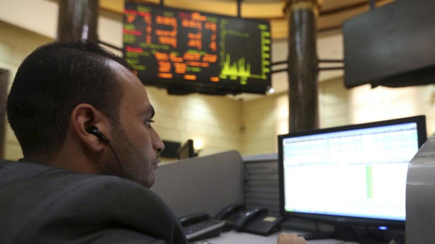 A trader works at the Egyptian stock exchange in Cairo, November 19, 2014. The Egyptian pound was flat at a central bank dollar sale on Wednesday but weakened significantly on the black market as Egypt's plans to repay a $2.5 billion Qatari deposit raised concerns of a looming dollar shortage, traders said. REUTERS/Mohamed Abd El Ghany (EGYPT - Tags: BUSINESS) - RTR4EQ3Y