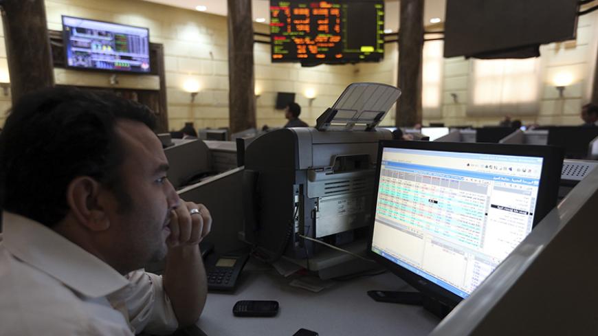 A trader works at the Egyptian stock exchange in Cairo November 19, 2014. The Egyptian pound was flat at a central bank dollar sale on Wednesday but weakened significantly on the black market as Egypt's plans to repay a $2.5 billion Qatari deposit raised concerns of a looming dollar shortage, traders said. REUTERS/Mohamed Abd El Ghany (EGYPT - Tags: BUSINESS) - RTR4EQ4F