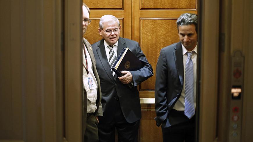 U.S. Senator Robert Menendez (D-NJ) (C) and Senator Brian Schatz (D-HI) (R) board an elevator as they take a break from a long series of votes, many on procedural matters or to confirm members of the Obama administration, at the U.S. Capitol in Washington December 13, 2014. The Senate passed a five-day extension of federal funding on Saturday, staving off a government shutdown and buying lawmakers more time to resolve a fight over a longer, $1.1 trillion spending bill led by Tea Party firebrand Ted Cruz.   