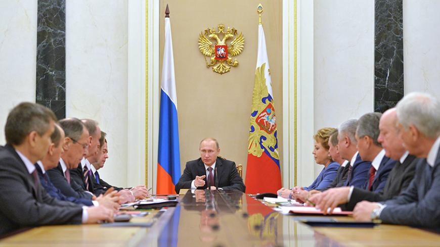 Russian President Vladimir Putin (C) chairs the Security Council in Moscow's Kremlin, December 26, 2014. Putin has signed a new military doctrine, naming NATO expansion among key external risks, the Kremlin said on Friday, days after Ukraine made fresh steps to join the Atlantic military alliance.  REUTERS/Alexei Druzhinin/RIA Novosti/Pool (RUSSIA - Tags: MILITARY POLITICS) ATTENTION EDITORS - THIS IMAGE HAS BEEN SUPPLIED BY A THIRD PARTY. IT IS DISTRIBUTED, EXACTLY AS RECEIVED BY REUTERS, AS A SERVICE TO C