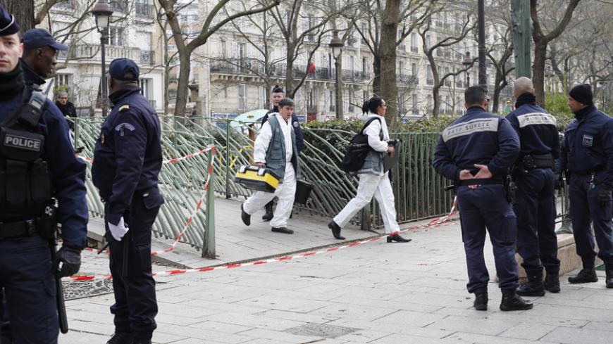 Policemen work at the scene after a shooting at the Paris offices of Charlie Hebdo January 7, 2015. Hooded gunmen stormed the Paris offices of the weekly satirical magazine known for lampooning radical Islam, killing at least 12 people, including two police officers in the worst militant attack on French soil in recent decades.   REUTERS/Youssef Boudlal  (FRANCE - Tags: CRIME LAW) - RTR4KFA9
