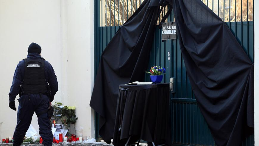 A Romanian gendarme looks on as he guards the French embassy with a gate draped in black behind a book of condolences for the victims of the attack at the headquarters of French weekly newspaper Charlie Hebdo, in Bucharest January 8, 2015. France began a day of mourning for the journalists and police officers shot dead on Wednesday morning by black-hooded gunmen who stormed the Paris offices of Charlie Hebdo, a weekly known for lampooning Islam and other religions.   REUTERS/Radu Sigheti (ROMANIA - Tags: CR