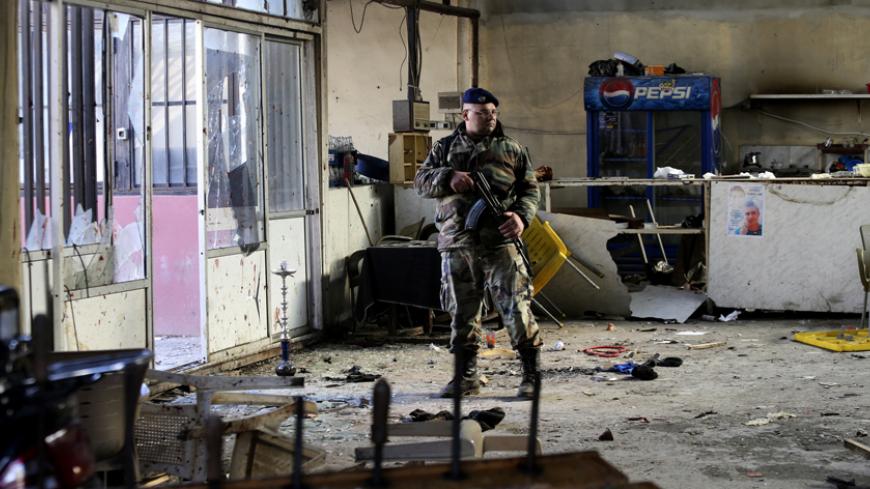 A Lebanese Army soldier stands guard inside a cafe where a suicide bomb attack took place in Jabal Mohsen, Tripoli January 11, 2015. At least seven people were killed after a cafe was attacked by a suicide bomber in the Lebanese city of Tripoli on Saturday.The al Qaeda-linked Nusra Front claimed responsibility for the attack on a Twitter account describing it as revenge for the Sunnis in Syria and Lebanon. REUTERS/Hasan Shaaban (LEBANON - Tags: POLITICS CIVIL UNREST MILITARY TPX IMAGES OF THE DAY) - RTR4KW9