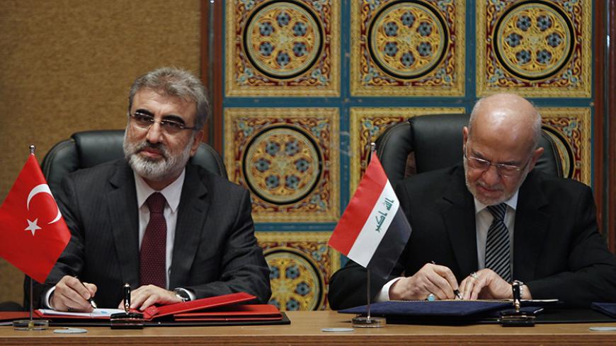 Turkey's Energy Minister Taner Yildiz (L) and Iraqi Foreign Minister Ibrahim al-Jaafari sign documents in Baghdad January 18, 2015.  Yildiz said on Sunday around 450,000 barrels per day (bpd) of Iraqi oil were currently flowing into his country's Ceyhan port.     REUTERS/Ahmed Saad    (IRAQ -Tags: POLITICS ENERGY) - RTR4LV6E