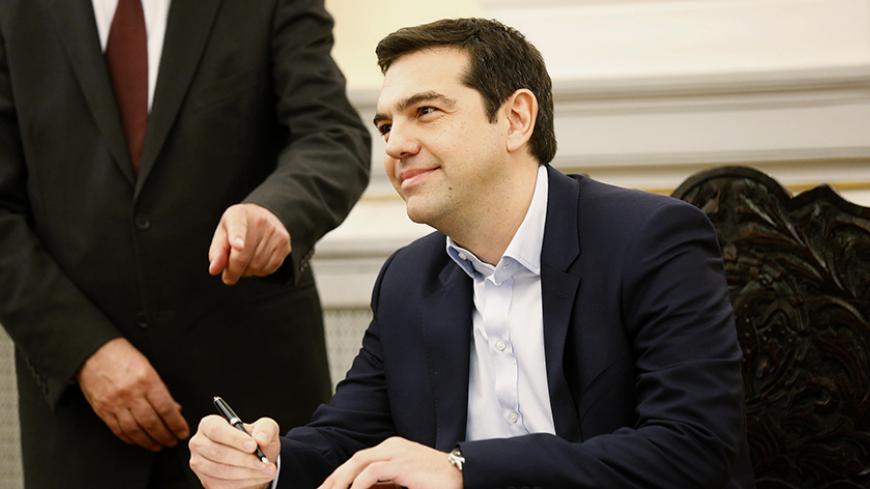 Alexis Tsipras, Syriza party leader and winner of the Greek parliamentary elections, signs papers appointing him as Greece's first leftist prime minister after his swearing-in ceremony at the presidential palace in Athens January 26, 2015. REUTERS/Yannis Behrakis (GREECE - Tags: POLITICS ELECTIONS) - RTR4MZDP