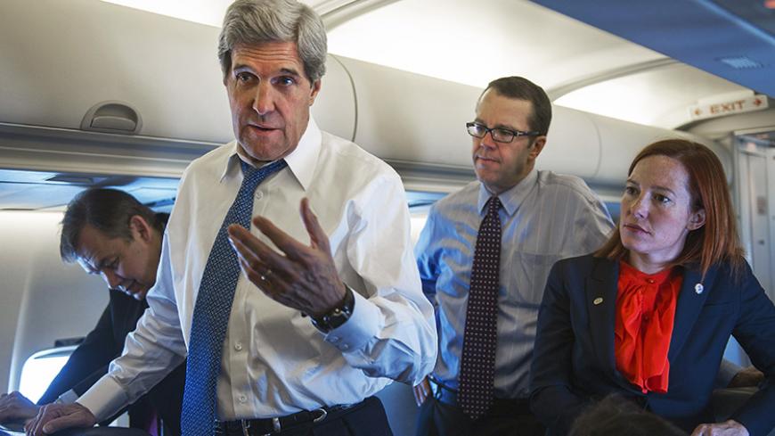 U.S. Secretary of State John Kerry (front) talks with reporters aboard his government aircraft shortly after departing Seoul Air Base April 13, 2013, for Beijing, China. To rear of Kerry are Senior Staff members Glen Johnson (2nd R) and Jen Psaki (R)    REUETRS/Paul J. Richards/Pool (SOUTH KOREA - Tags: POLITICS) - RTXYJO9