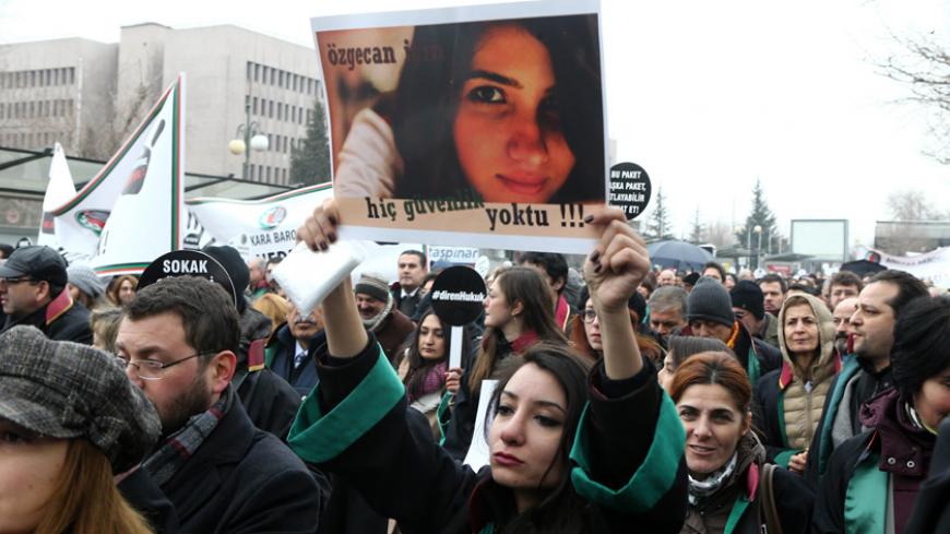 A Member of Turkey's Bar Association holds a poster depicting slain Ozgecan Aslan, in Ankara, on February 16, 2015 during a march to protest against a law that strenghtens the police's power. Anger mounted in Turkey Monday over the murder and attempted rape by a bus driver of the 20-year-old female student whose burned body was discovered on February 13, as a court placed three suspects in pre-trial detention over the brutal killing. AFP PHOTO/ADEM ALTAN        (Photo credit should read ADEM ALTAN/AFP/Getty