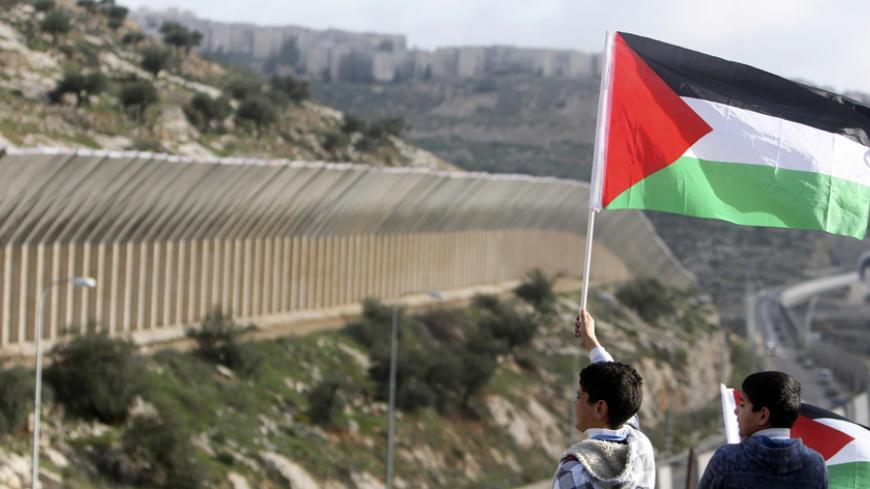 Palestinian youths hold Palestinian flags during a demonstration against the construction of a section of the controversial Israeli barrier in the West Bank town of Beit Jala near Bethlehem March 4, 2010. REUTERS/Ammar Awad (WEST BANK - Tags: POLITICS CIVIL UNREST) - RTR2B7EQ