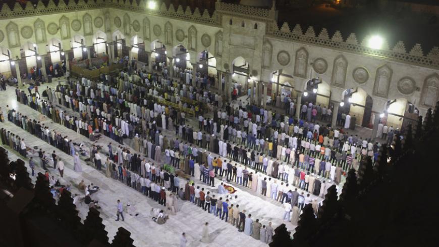 Muslims conduct taraweeh prayers as they gather specially for Lailat al-Qadr, at Al-Azhar Mosque in Cairo July 24, 2014. Lailat al-Qadr (Night of Decree) is the night the first verses of the Koran were revealed to the Prophet Mohammad, but it is believed to have taken place on the 27th night of the Muslim month of Ramadan, according to most Muslim historians.  REUTERS/Asmaa Waguih  (EGYPT - Tags: RELIGION) - RTR401P9