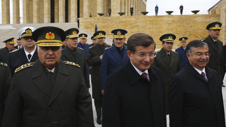 Turkey's Prime Minister Ahmet Davutoglu (C), Chief of Staff General Necdet Ozel (L) and Defence Minister Ismet Yilmaz (R), leave after a wreath-laying ceremony with members of the High Military Council at Anitkabir, the mausoleum of modern Turkey's founder Mustafa Kemal Ataturk, ahead of a High Military Council meeting in Ankara, November 27, 2014. REUTERS/Umit Bektas (TURKEY - Tags: POLITICS MILITARY) - RTR4FS8X