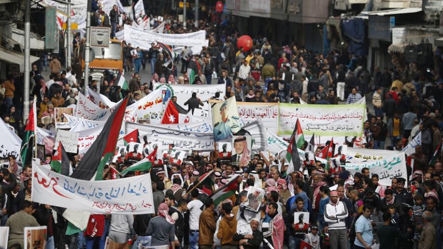Jordanian protesters hold up pictures of Jordan's King Abdullah and Jordanian pilot Muath al-Kasaesbeh, as they chant slogans during a march after Friday prayers in downtown Amman February 6, 2015. Thousands of Jordanians gathered to show their loyalty to the King and to show solidarity with the family of the pilot, Muath al-Kasasbeh, killed by Islamic State. REUTERS/Muhammad Hamed (JORDAN - Tags: POLITICS CIVIL UNREST) - RTR4OI2P