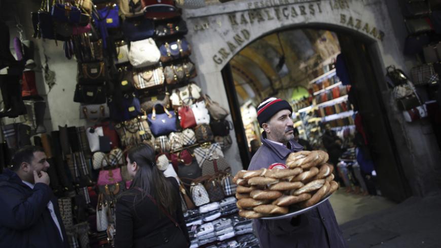 A street vendor sells traditional Turkish bagels, simit, outside the historical Grand Bazaar, known as the Covered Bazaar, in Istanbul January 3, 2014. When a senior Turkish businessman publicly criticised the central bank this week for failing to stabilise the tumbling lira currency, he was taking aim at a pillar of support for the government: its reputation for strong economic management. Monetary policy "is causing losses to companies which made transactions trusting in the central bank", complained Mehm