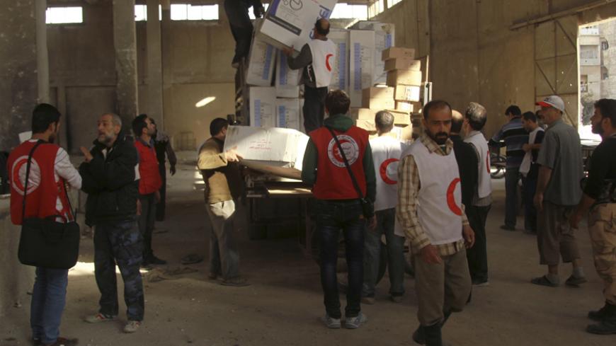 Workers and members of the Syrian Arab Red Crescent unload boxes of humanitarian and medical aid in the rebel-controlled area of Aleppo's Bustan al-Qasr October 28, 2014. REUTERS/Ammar Abdullah  (SYRIA - Tags: POLITICS CIVIL UNREST CONFLICT) - RTR4BWB4