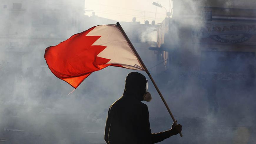 A protester carries a Bahraini flag as they clash with riot police in the village of Bilad Al Qadeem south of Manama, February 6, 2015.
 Protesters clashed with riot police demanding for the release of Bahraini opposition leader Sheik Ali Salman. Sheik Salman, head of the al-Wefaq Islamic Society was arrested on December 28, 2014 after leading a protest rally against elections in November which his party boycotted.  REUTERS/ Hamad I Mohammed (BAHRAIN). - Tags: POLITICS CIVIL UNREST) - RTR4OIT8
