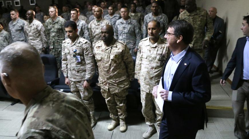 U.S. Secretary of Defense Ash Carter (R) arrives to address troops at Camp Arifjan, Kuwait February 23, 2015. Carter is gathering top U.S. military commanders and diplomats for talks in Kuwait on Monday about the battle against Islamic State, as America's military effort approaches major hurdles in both Iraq and Syria.   REUTERS/Jonathan Ernst    (KUWAIT - Tags: POLITICS MILITARY) - RTR4QS89