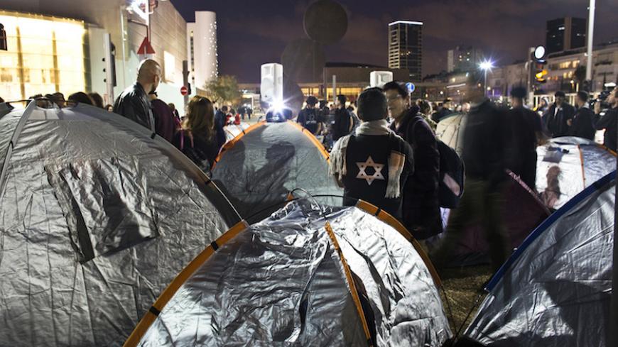 Israeli activists stand near tents on a main boulevard in the coastal city of Tel Aviv March 1, 2015. Dozens of Israeli social activists pitched tents in Tel Aviv on Sunday protesting about a housing shortage which is a key issue in campaigning for a March 17 election. The protest was reminiscent of a similar demonstration against a housing shortage in 2011 that ignited social protests of unprecedented size in Israel. REUTERS/Nir Elias (ISRAEL - Tags: POLITICS CIVIL UNREST) - RTR4RNTC