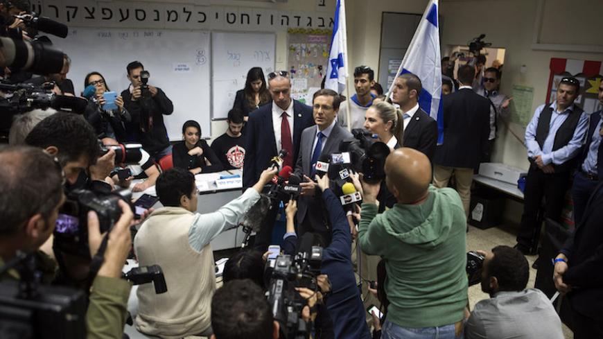 Isaac Herzog (C), co-leader of the centre-left Zionist Union party, speaks to the media after voting for the parliamentary election at a polling station in Tel Aviv March 17, 2015. Israeli Prime Minister Benjamin Netanyahu's march towards becoming the longest-serving leader of Israel could be halted on Tuesday in an election that has exposed public fatigue with his stress on national security rather than socio-economic problems. Surging rhetoric against Iran and the Palestinians has done little to close Net