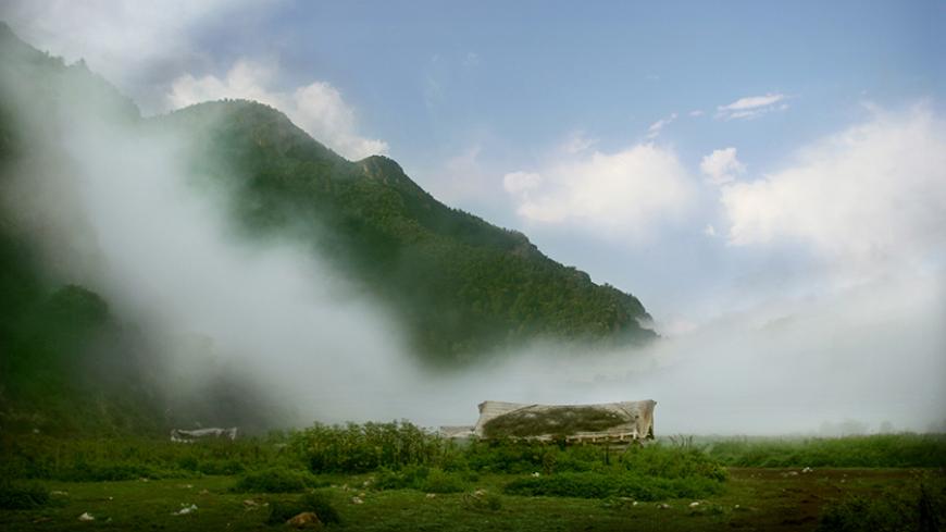A view of a cottage in fog at Daryasar field in Mazandaran Province, 300 km (186 miles) north of Tehran September 21, 2005. Picture taken on September 21. REUTERS/Morteza Nikoubazl - RTRP68C