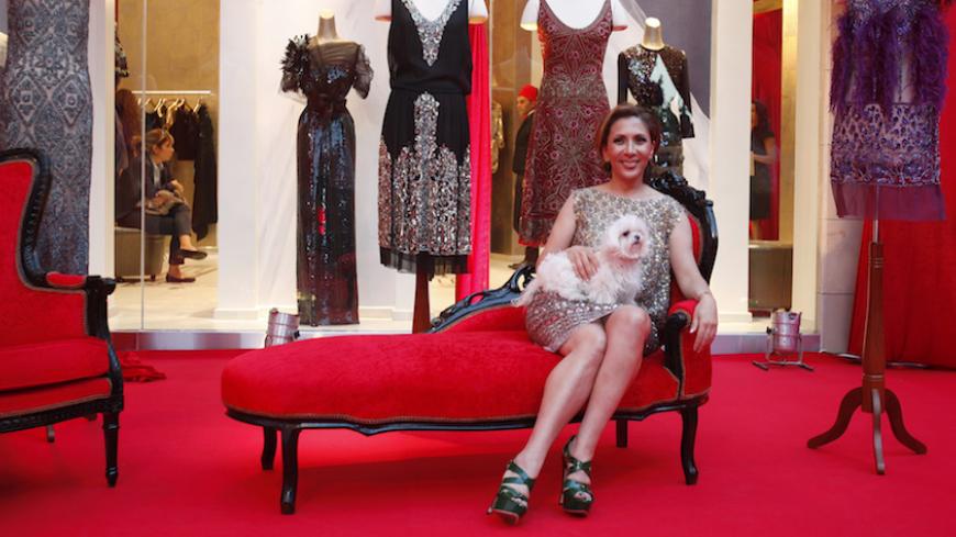 Lebanese American designer Reem Acra poses with her dog Loulou during the opening of the first Reem Acra boutique in downtown Beirut, November 3, 2010. REUTERS/Cynthia Karam  (LEBANON - Tags: FASHION BUSINESS) - RTXU6CK